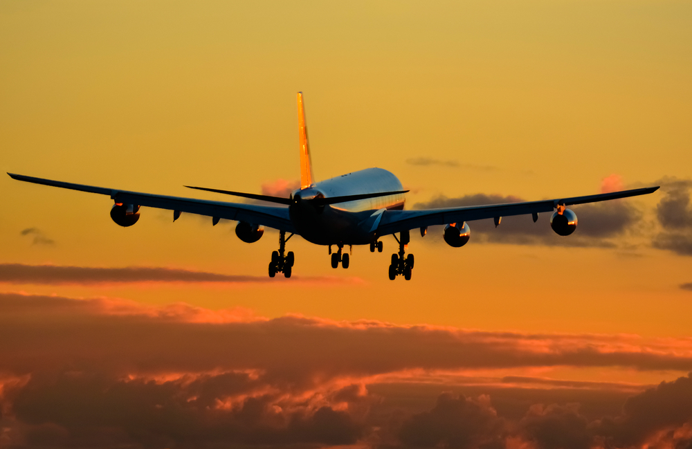 An aircraft climbing at sunset